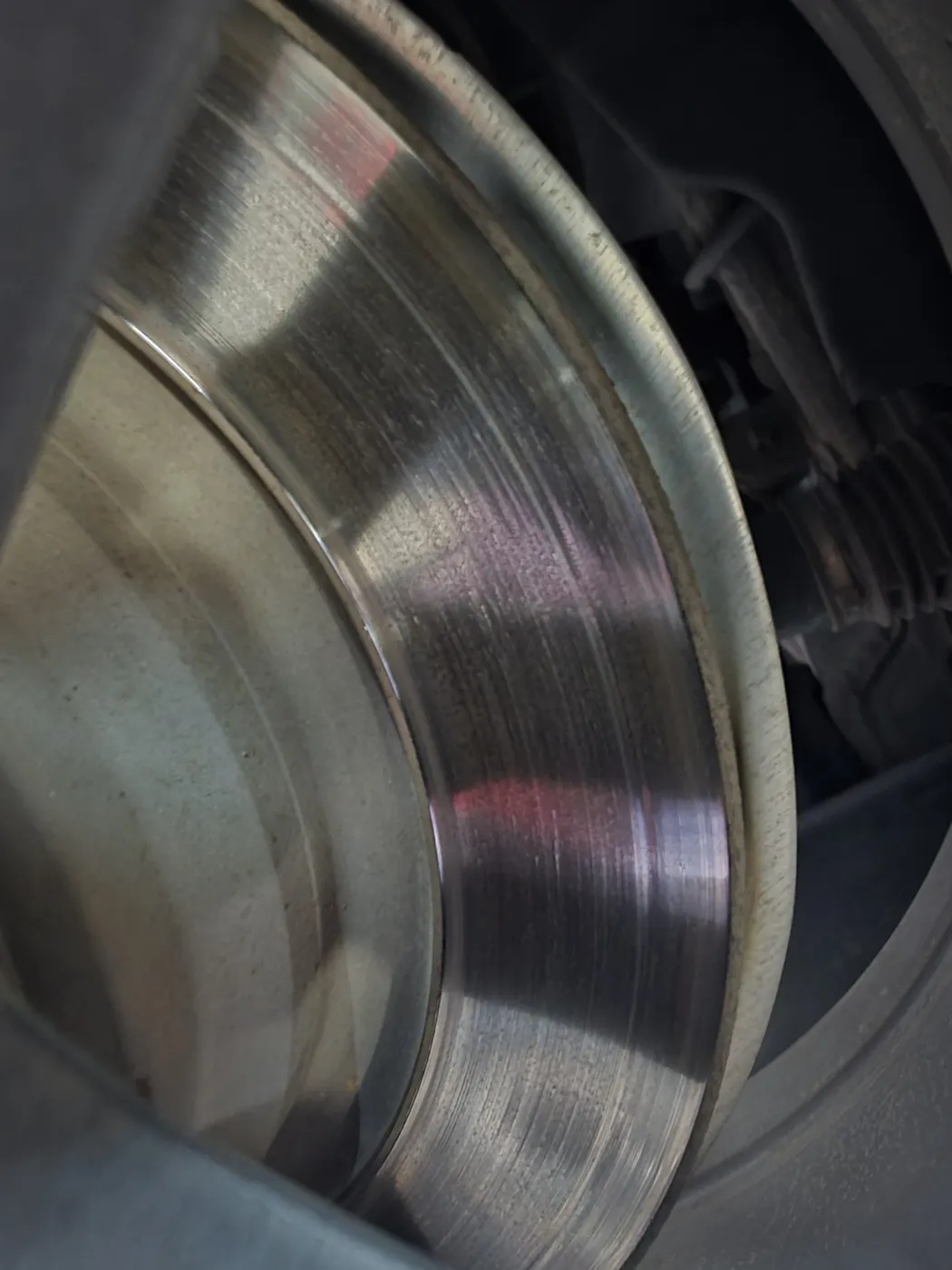 Close-up of a brake rotor braking surface behind the wheel hub