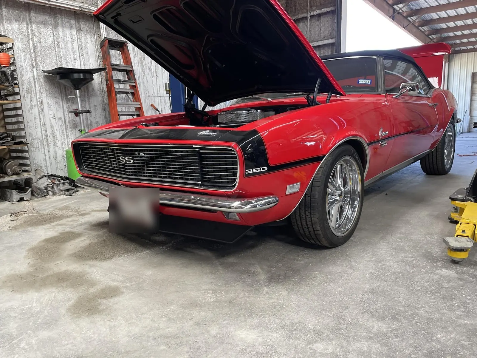 Red Chevrolet Camaro SS with the hood up in the shop