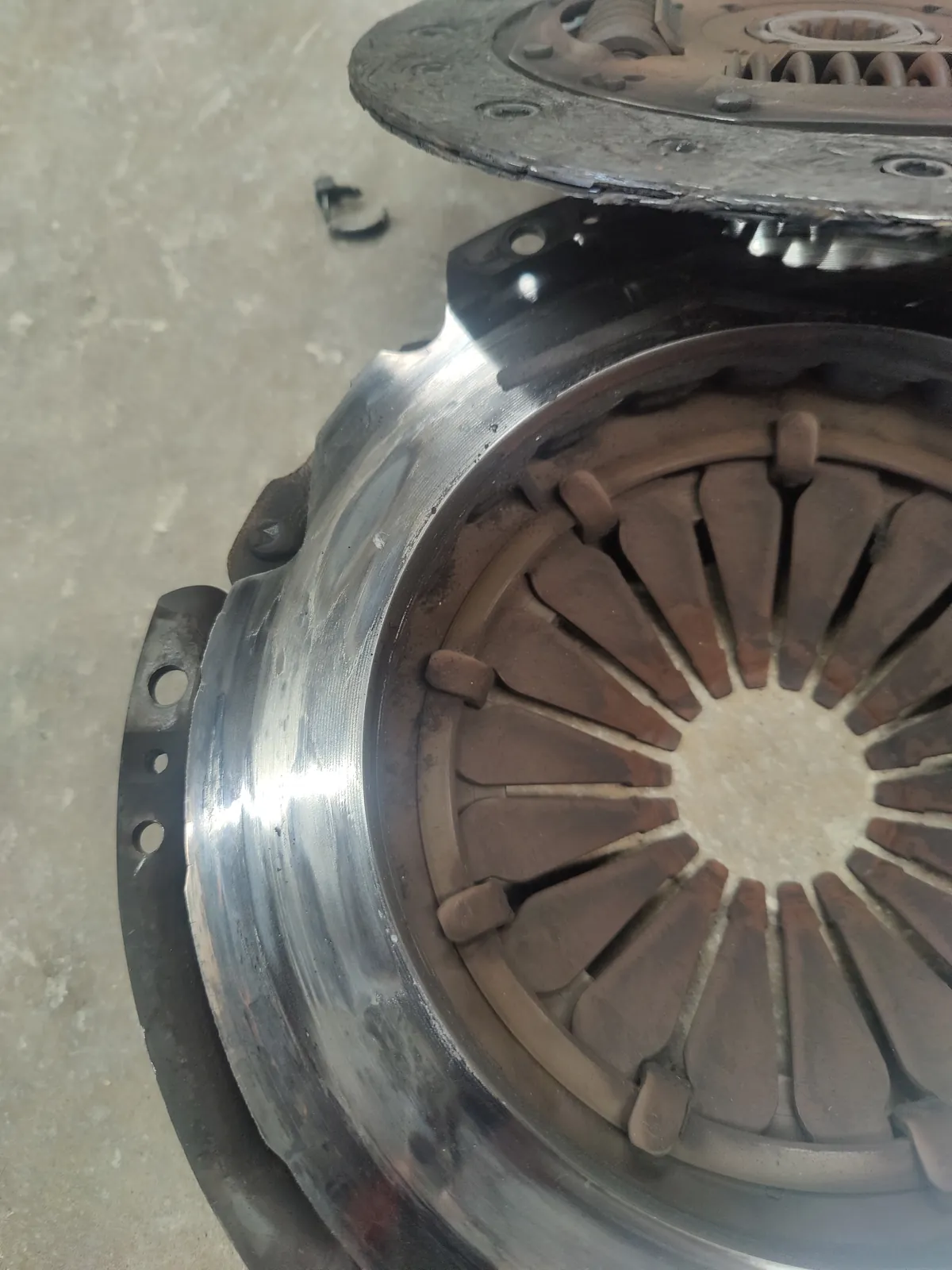 Worn clutch disc and pressure plate removed from a car
