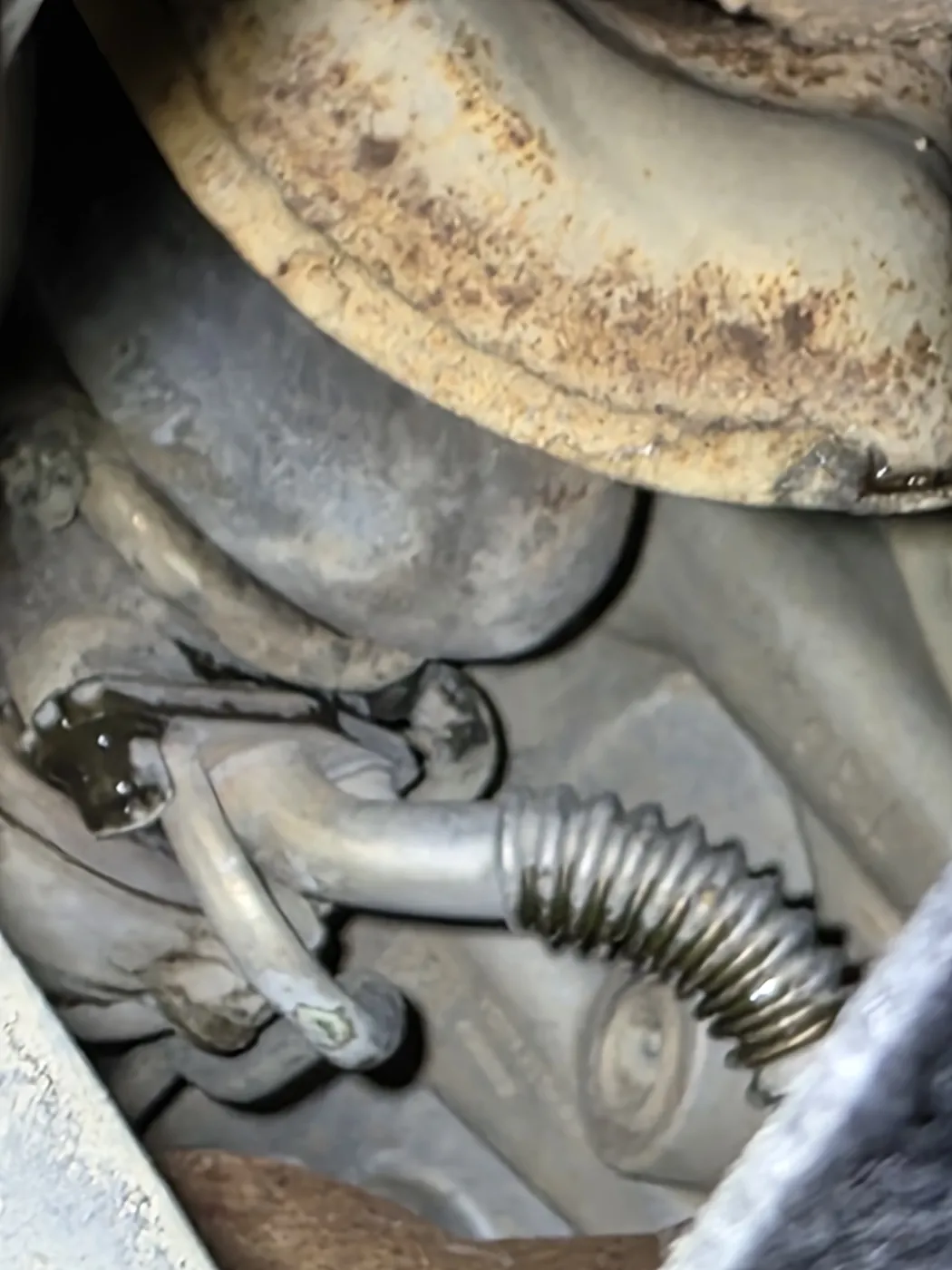 Exhaust components and heat shield under a car during an exhaust inspection