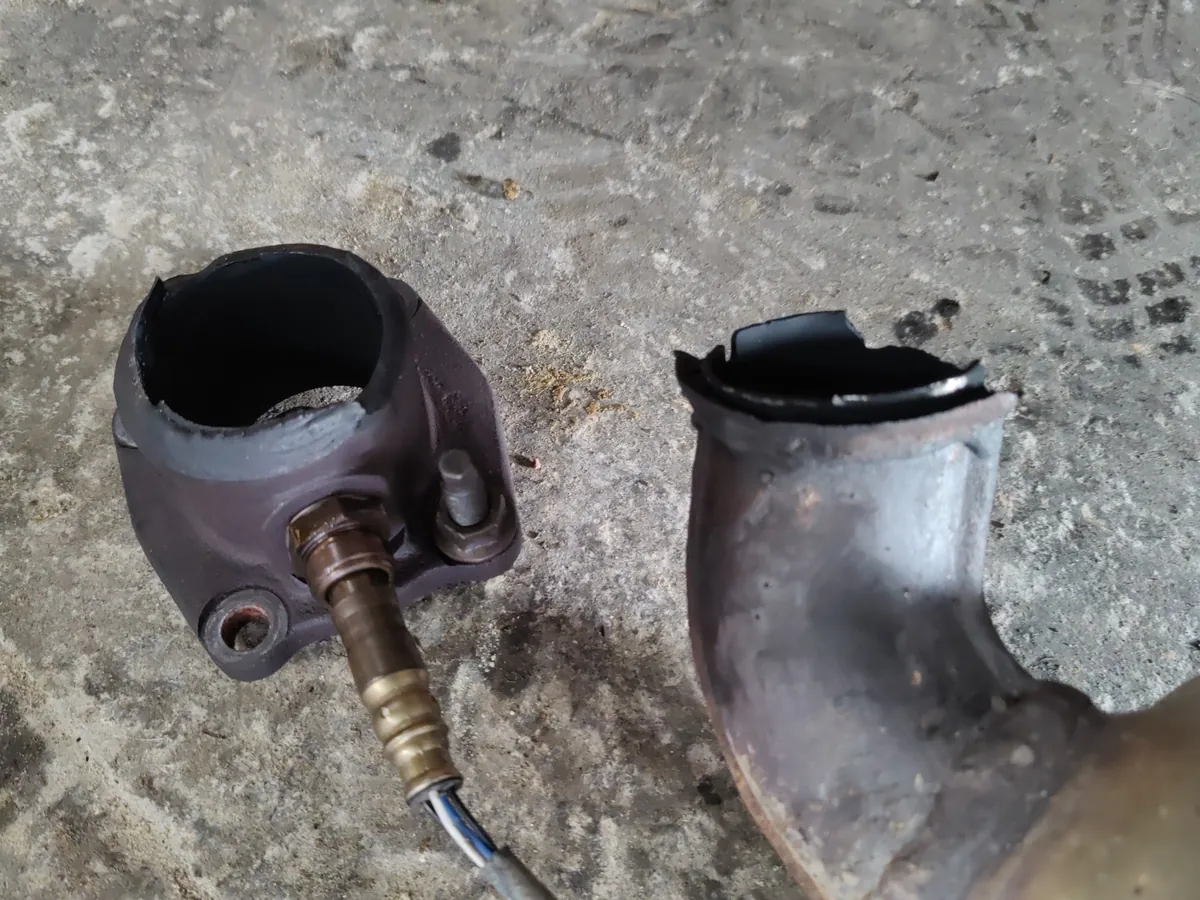 Removed exhaust pipe and oxygen sensor on the shop floor during an exhaust repair