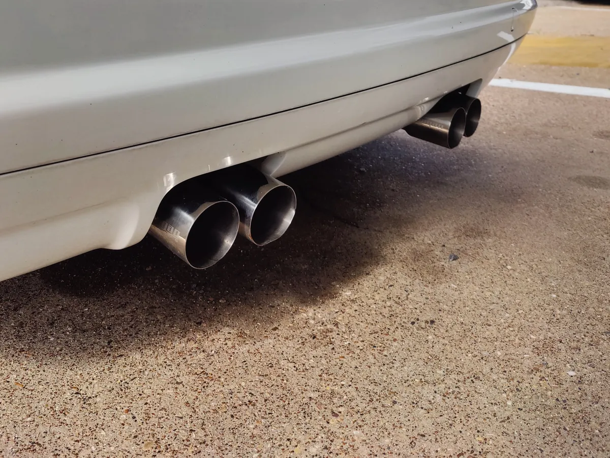 Quad exhaust tips on a silver BMW