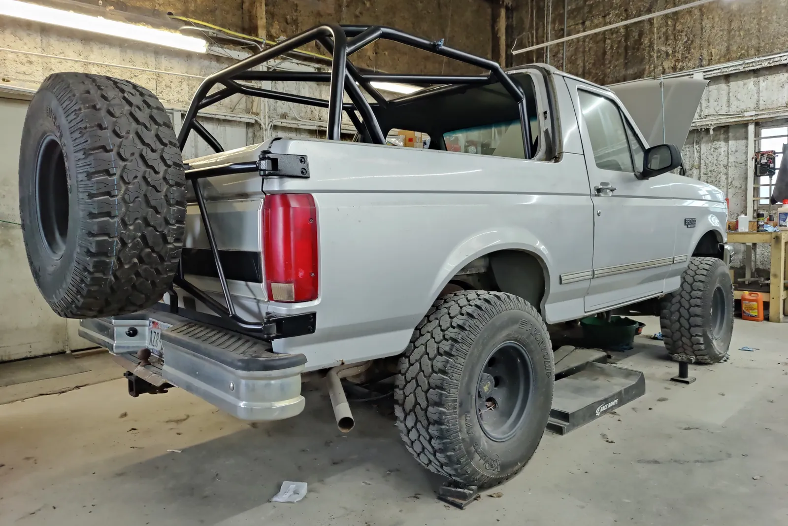 Lifted 1990s Ford Bronco with a roll cage in the Figure Automotive shop