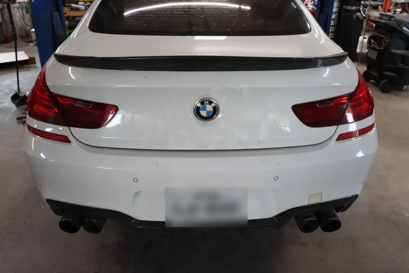 Rear of a white BMW 6 Series Gran Coupe in the shop