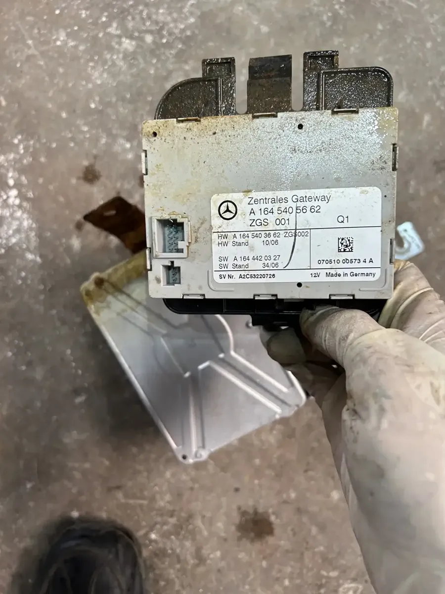 Technician holding a corroded Mercedes-Benz control module