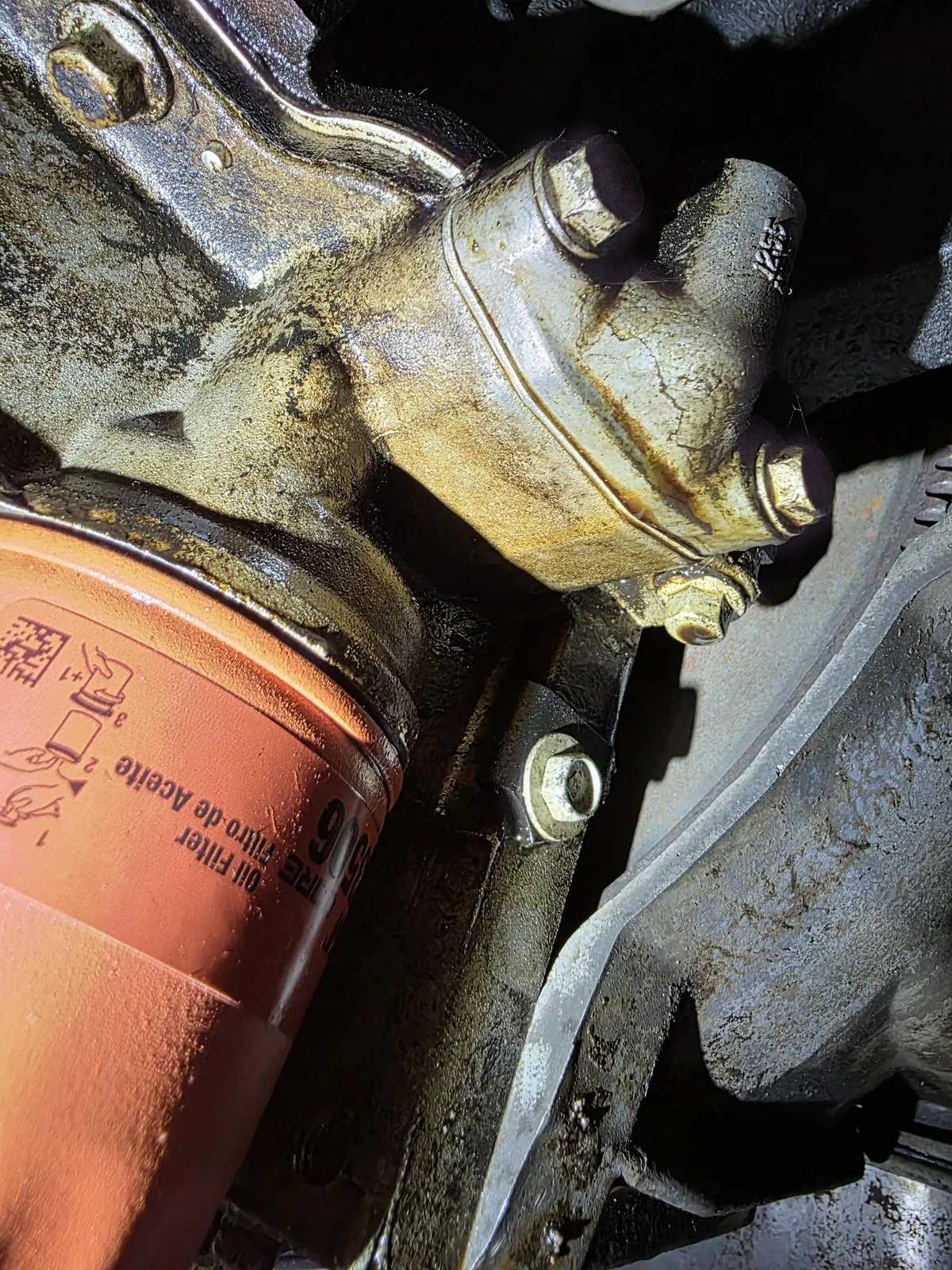 Close-up of an oil filter and its housing under a car