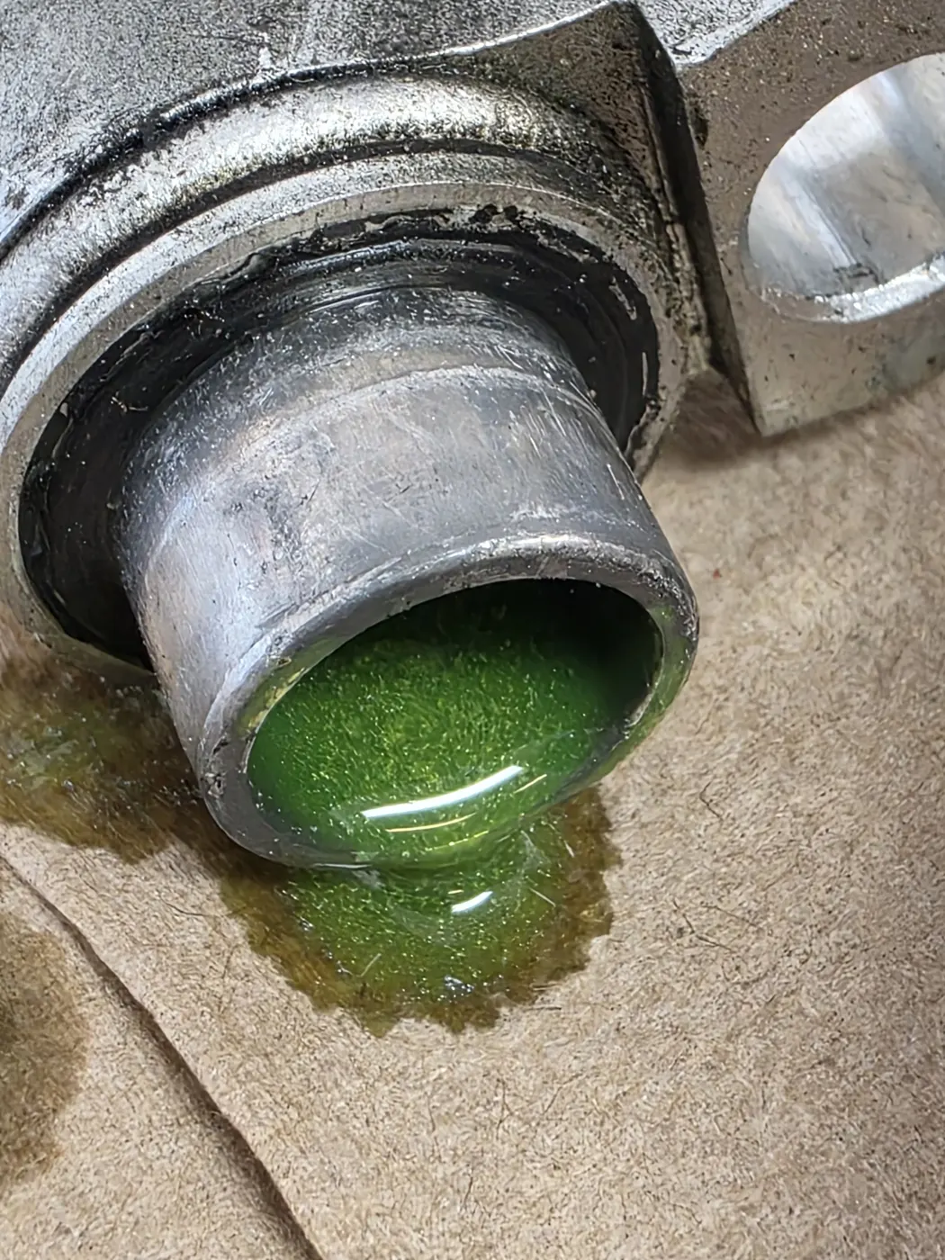 Green coolant pooling out of a removed radiator outlet
