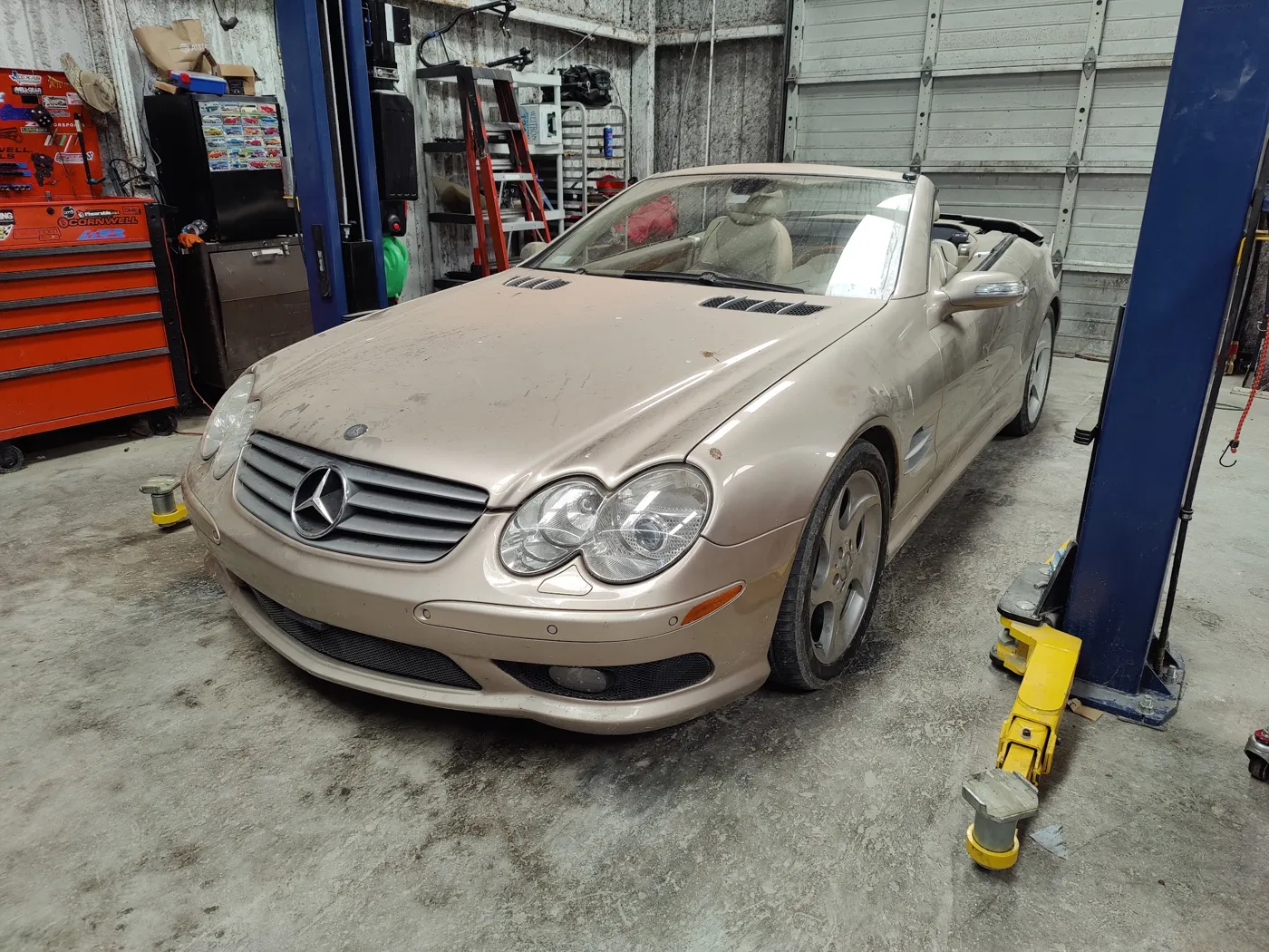 Silver Mercedes-Benz SL convertible up on a lift in the shop