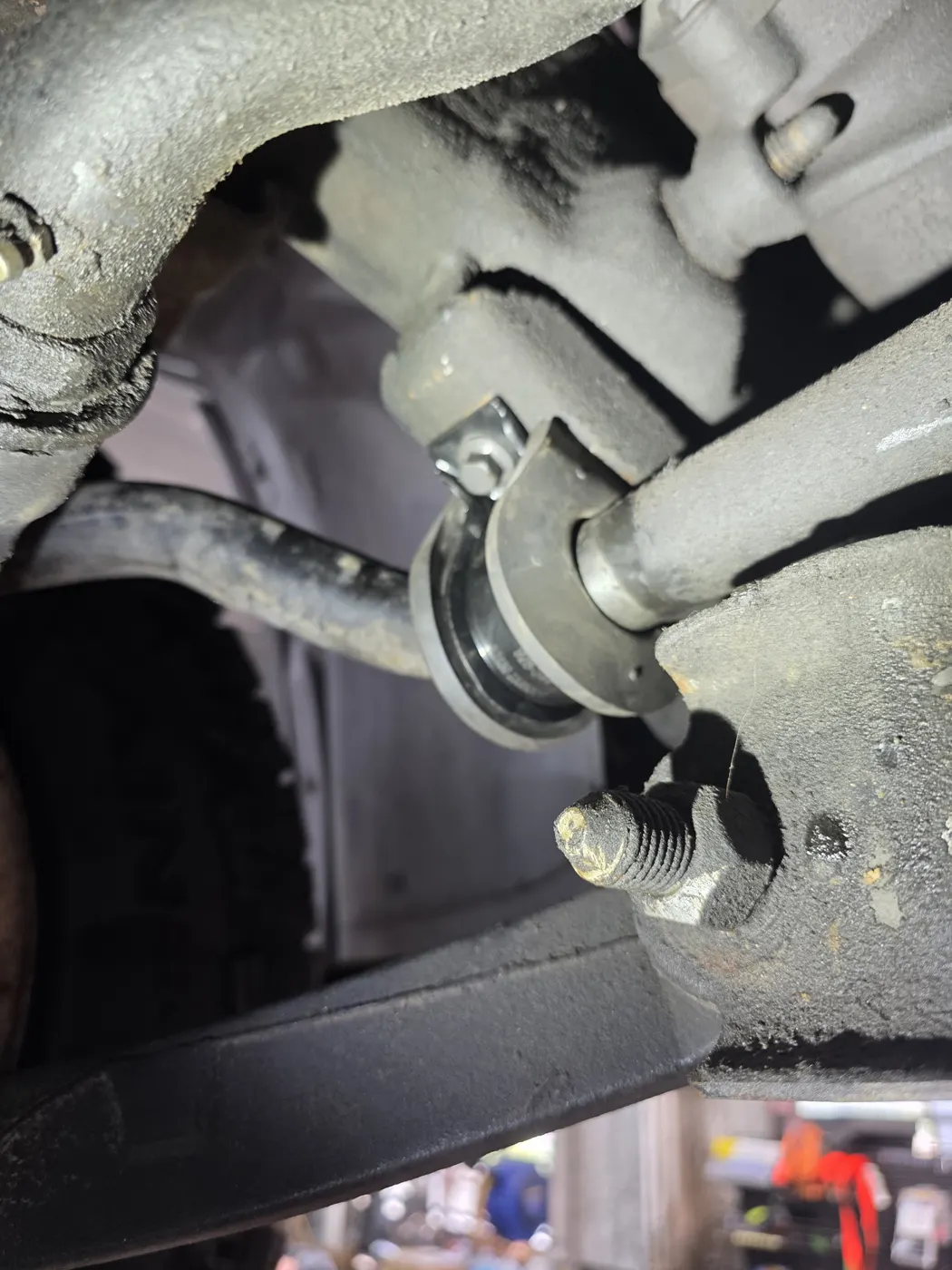 Sway bar link and strut assembly behind the wheel