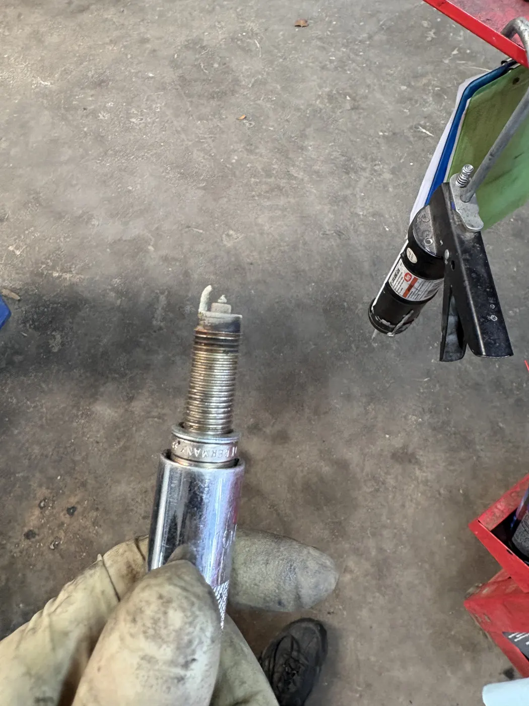 Old spark plug being removed with a socket